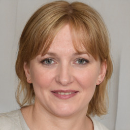 Joyful white adult female with medium  brown hair and blue eyes