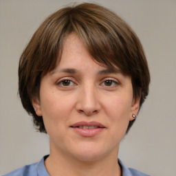 Joyful white young-adult female with medium  brown hair and grey eyes