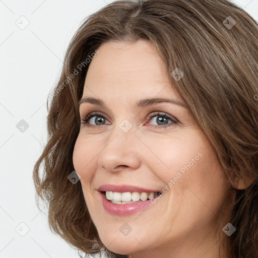 Joyful white young-adult female with long  brown hair and green eyes