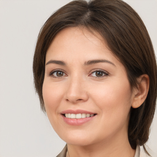 Joyful white young-adult female with medium  brown hair and brown eyes