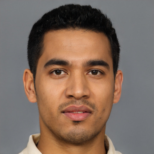 Joyful latino young-adult male with short  black hair and brown eyes