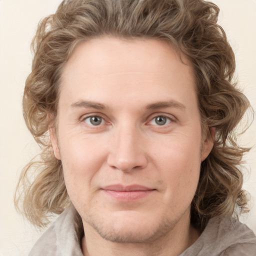 Joyful white young-adult male with medium  brown hair and grey eyes