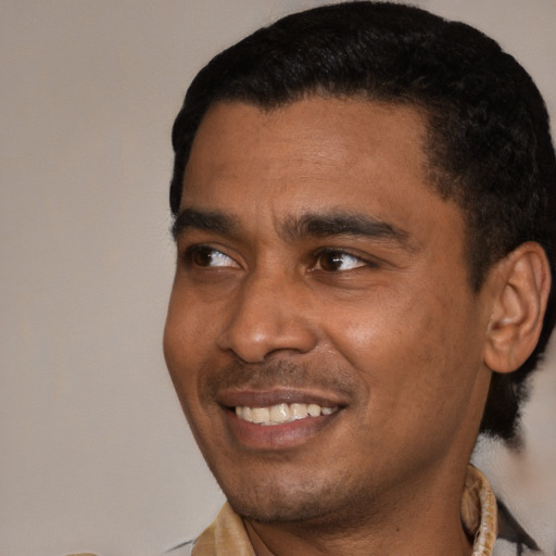 Joyful black young-adult male with short  black hair and brown eyes