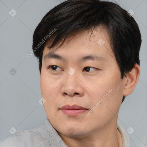 Joyful asian young-adult male with short  brown hair and brown eyes