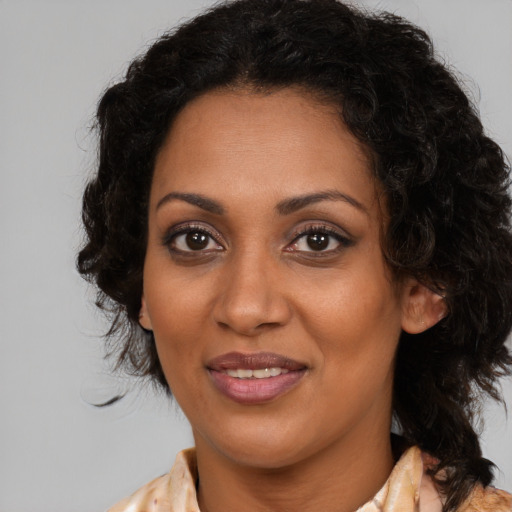 Joyful black adult female with medium  brown hair and brown eyes