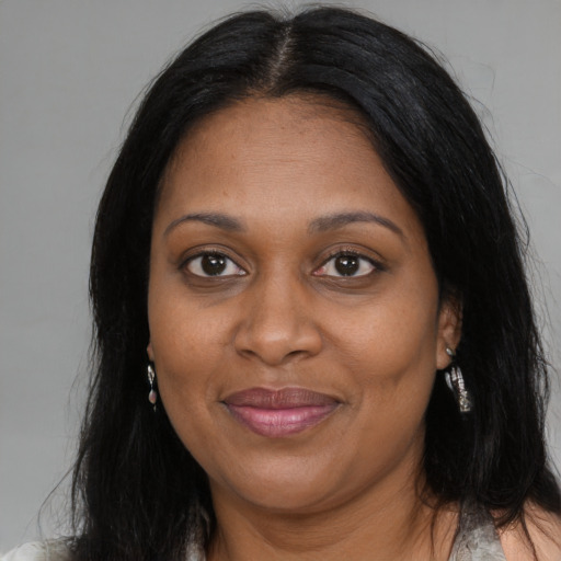 Joyful black adult female with long  brown hair and brown eyes