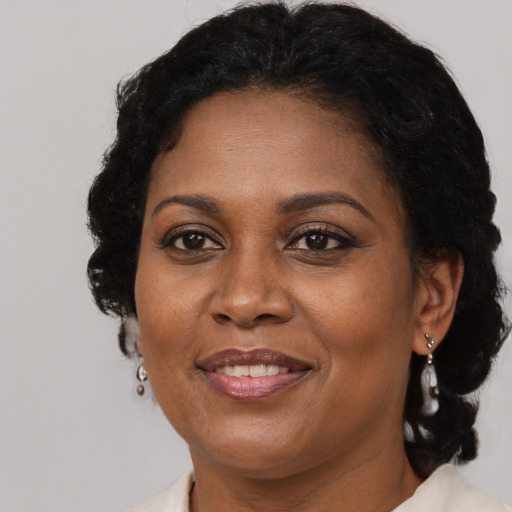 Joyful black adult female with long  brown hair and brown eyes