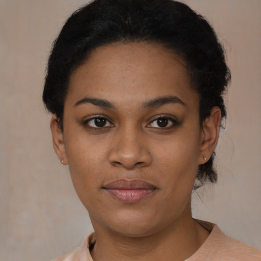 Joyful black young-adult female with short  black hair and brown eyes
