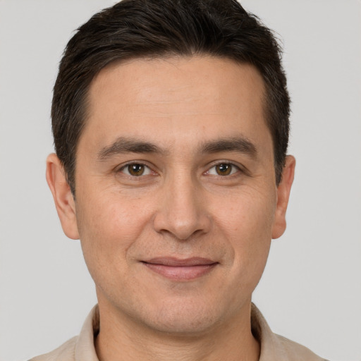 Joyful white adult male with short  brown hair and brown eyes