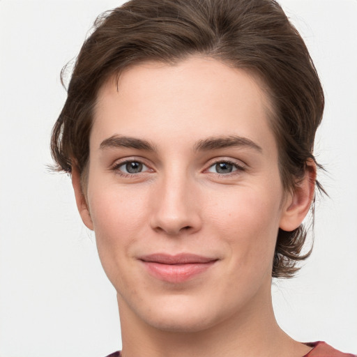 Joyful white young-adult female with short  brown hair and grey eyes