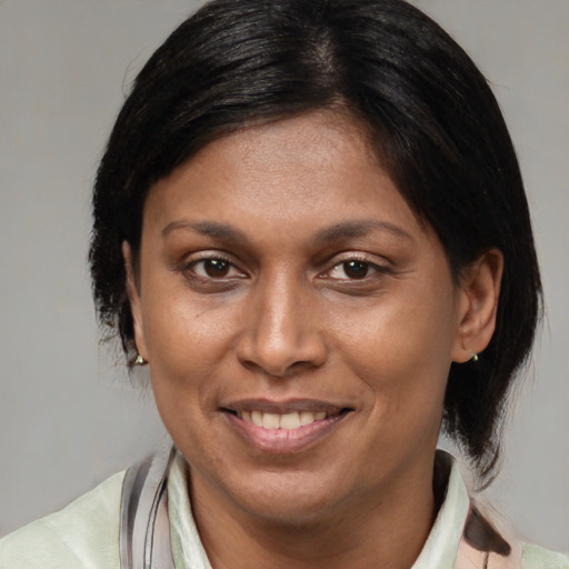 Joyful black adult female with medium  brown hair and brown eyes