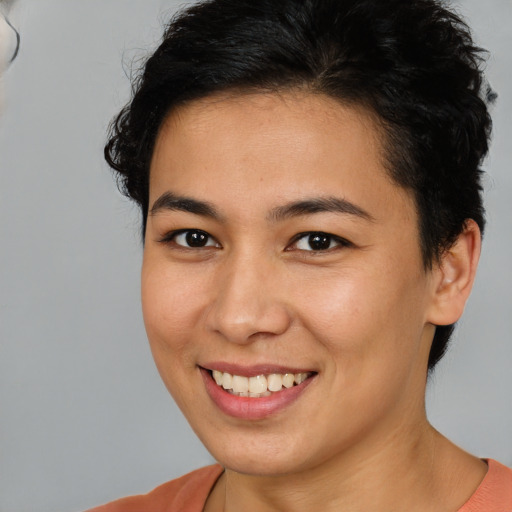 Joyful latino young-adult female with short  brown hair and brown eyes