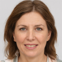 Joyful white adult female with medium  brown hair and grey eyes