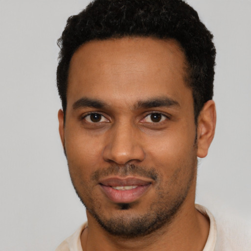 Joyful black young-adult male with short  black hair and brown eyes