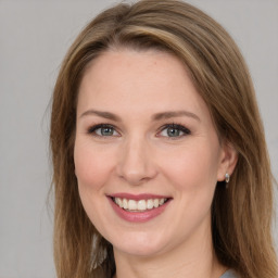 Joyful white young-adult female with long  brown hair and grey eyes