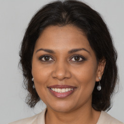 Joyful black adult female with medium  brown hair and brown eyes