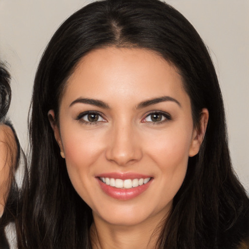 Joyful white young-adult female with long  brown hair and brown eyes