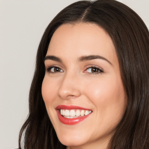 Joyful white young-adult female with long  brown hair and brown eyes