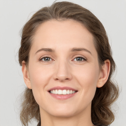 Joyful white young-adult female with medium  brown hair and green eyes