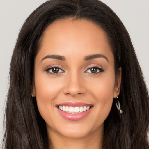 Joyful latino young-adult female with long  brown hair and brown eyes