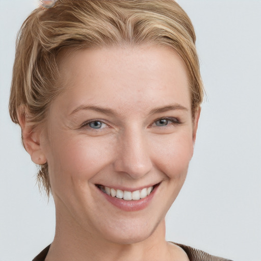 Joyful white young-adult female with short  brown hair and blue eyes