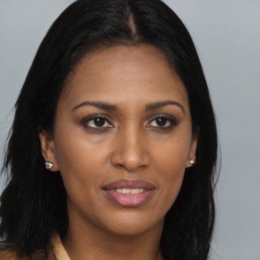 Joyful black young-adult female with long  brown hair and brown eyes