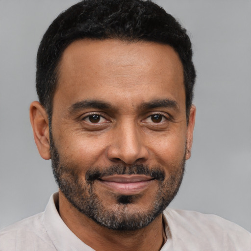Joyful black young-adult male with short  brown hair and brown eyes