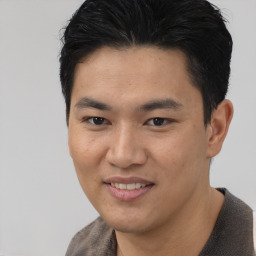 Joyful asian young-adult male with short  black hair and brown eyes