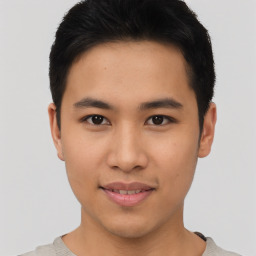 Joyful asian young-adult male with short  brown hair and brown eyes