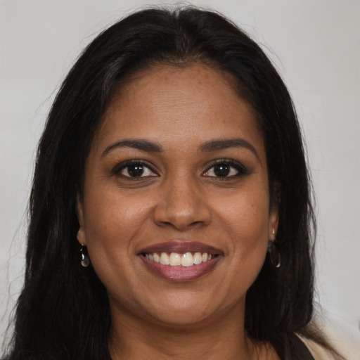 Joyful black young-adult female with long  brown hair and brown eyes