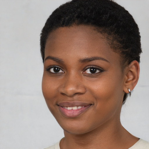 Joyful black young-adult female with short  brown hair and brown eyes