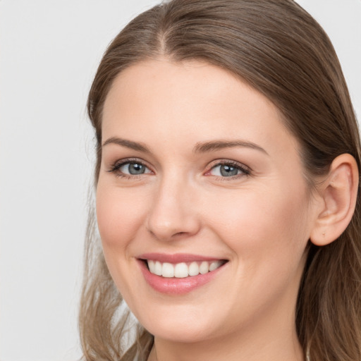 Joyful white young-adult female with long  brown hair and grey eyes