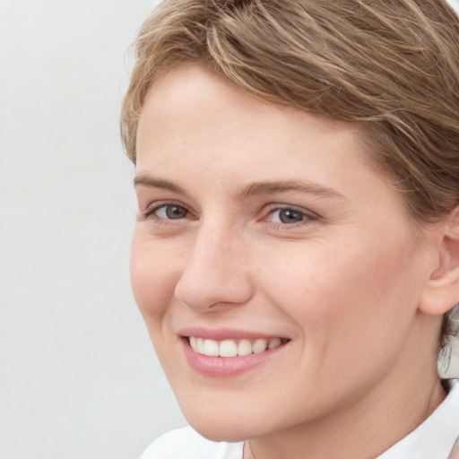 Joyful white young-adult female with short  brown hair and grey eyes