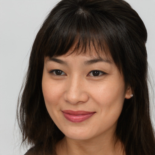 Joyful asian young-adult female with long  brown hair and brown eyes