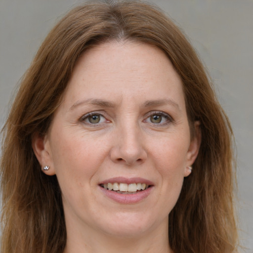 Joyful white adult female with long  brown hair and green eyes