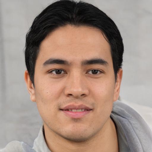 Joyful asian young-adult male with short  black hair and brown eyes