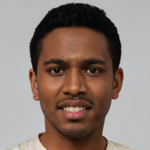 Joyful black young-adult male with short  black hair and brown eyes