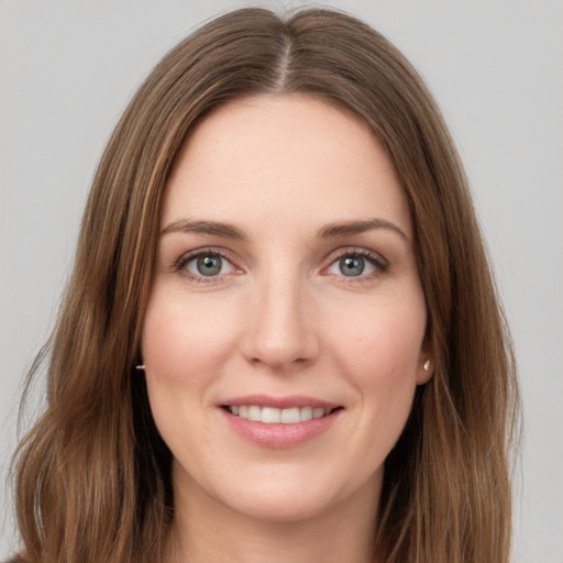 Joyful white young-adult female with long  brown hair and green eyes