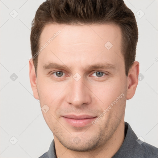 Joyful white young-adult male with short  brown hair and grey eyes