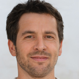 Joyful white adult male with short  brown hair and brown eyes