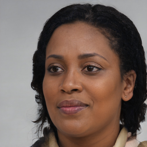 Joyful black young-adult female with medium  black hair and brown eyes