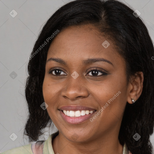 Joyful black young-adult female with long  brown hair and brown eyes