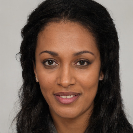 Joyful black young-adult female with long  brown hair and brown eyes