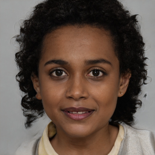 Joyful black young-adult female with medium  brown hair and brown eyes