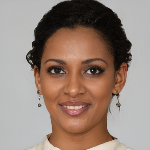Joyful black young-adult female with short  black hair and brown eyes