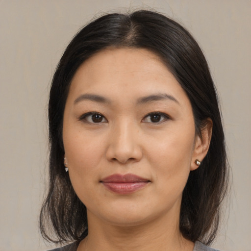 Joyful asian young-adult female with medium  brown hair and brown eyes