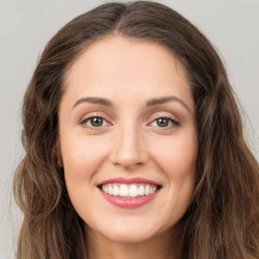 Joyful white young-adult female with long  brown hair and brown eyes