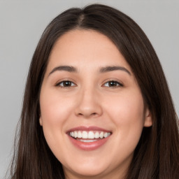 Joyful white young-adult female with long  brown hair and brown eyes