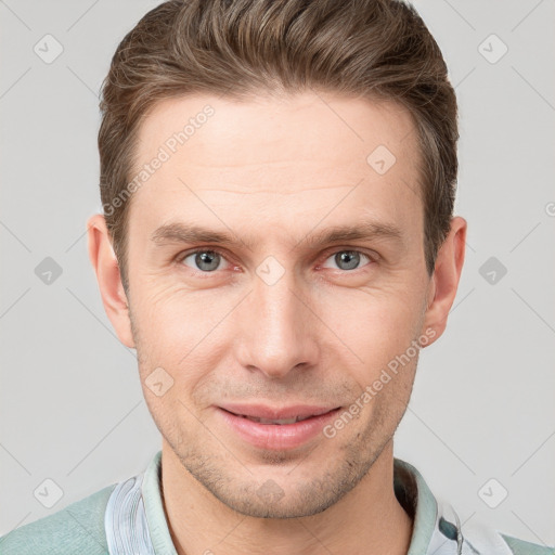 Joyful white young-adult male with short  brown hair and grey eyes