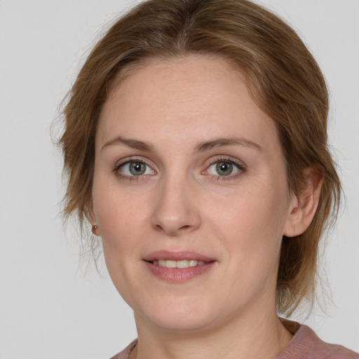 Joyful white young-adult female with medium  brown hair and green eyes